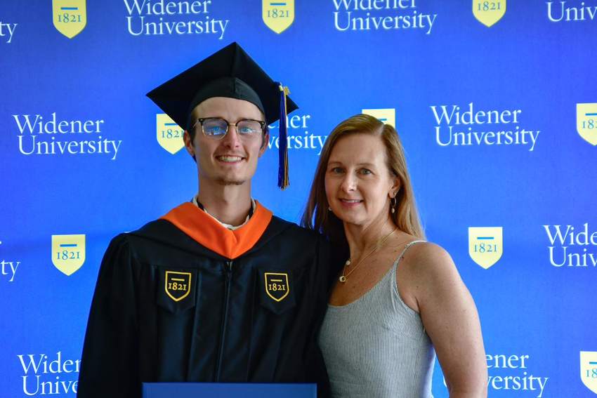 Cole in black robes at Widener master's graduation